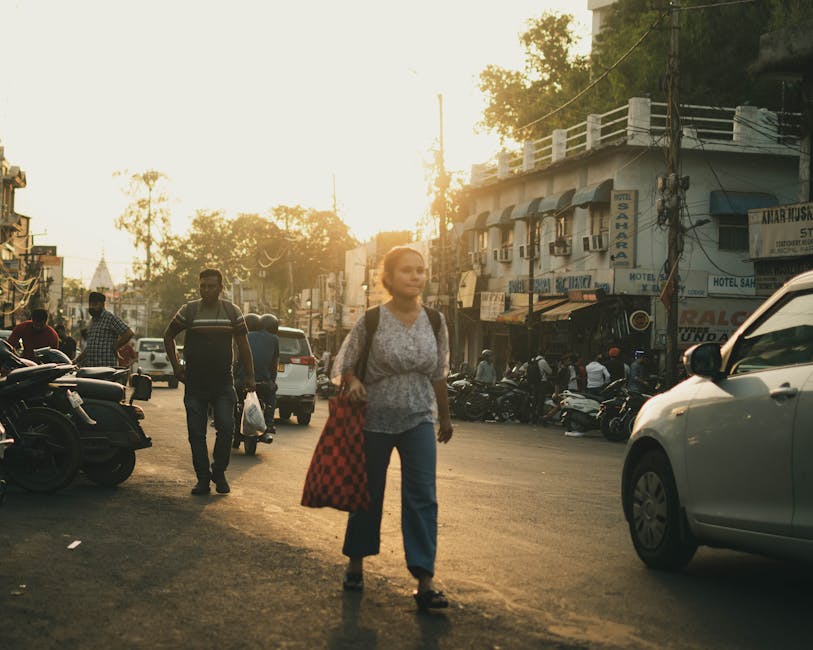 A woman walking down a street with cars and people